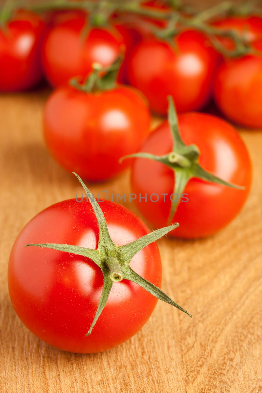 Fresh cocktail tomatoes ona wooden table.