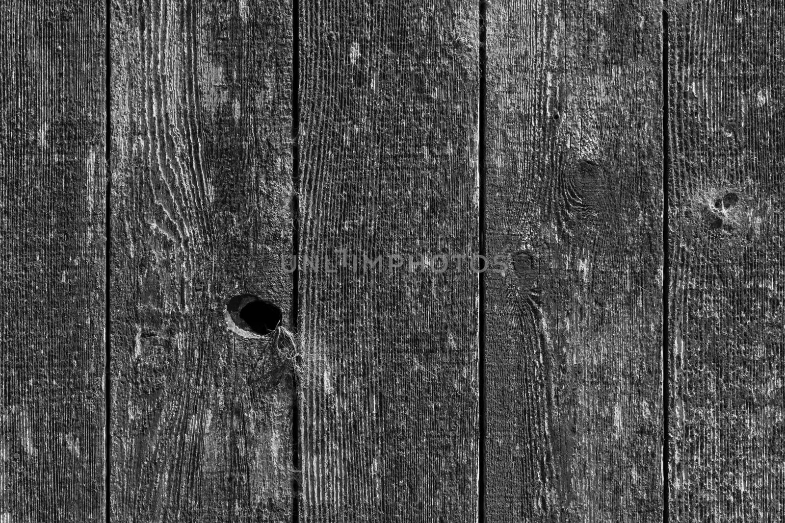 Black and white image of the side of an old barn.