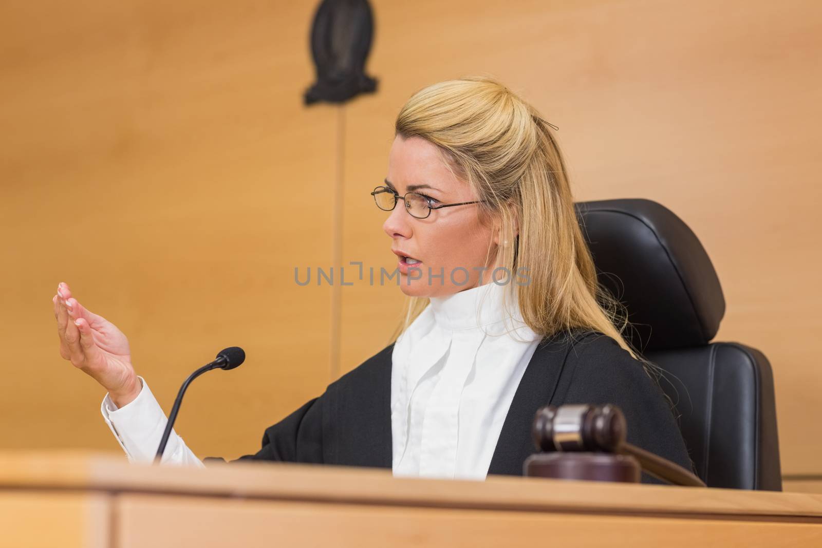 Stern judge speaking to the court by Wavebreakmedia