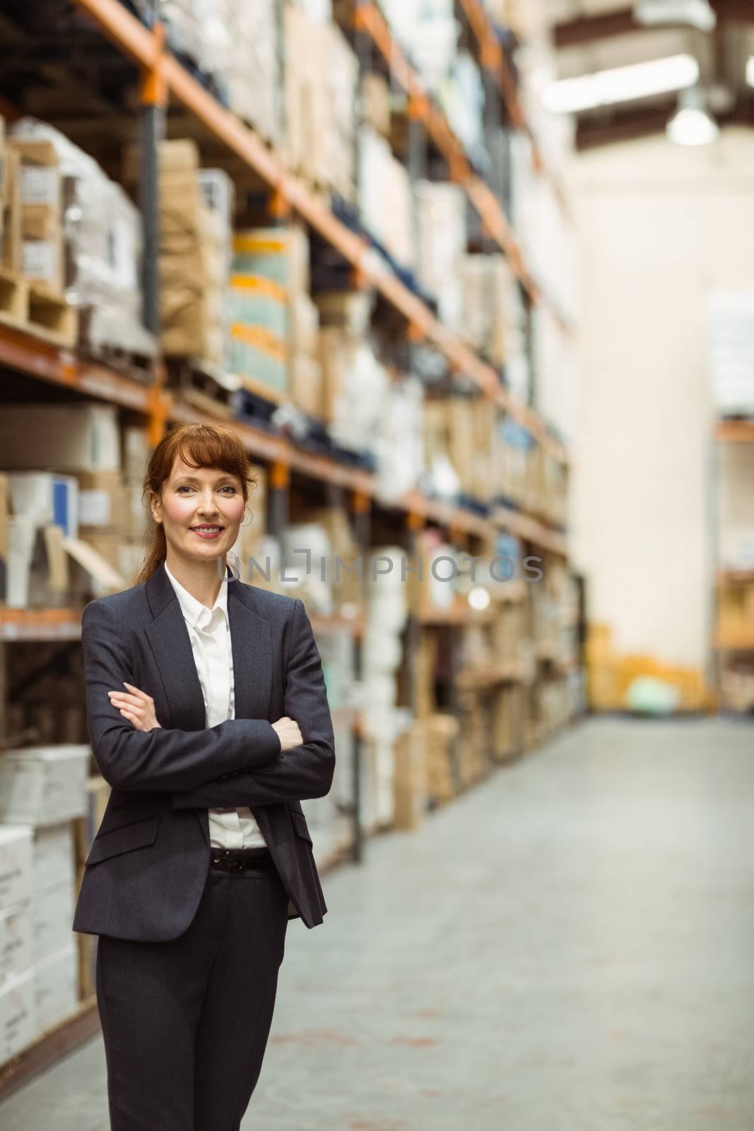 Female manager with arms crossed in a large warehouse