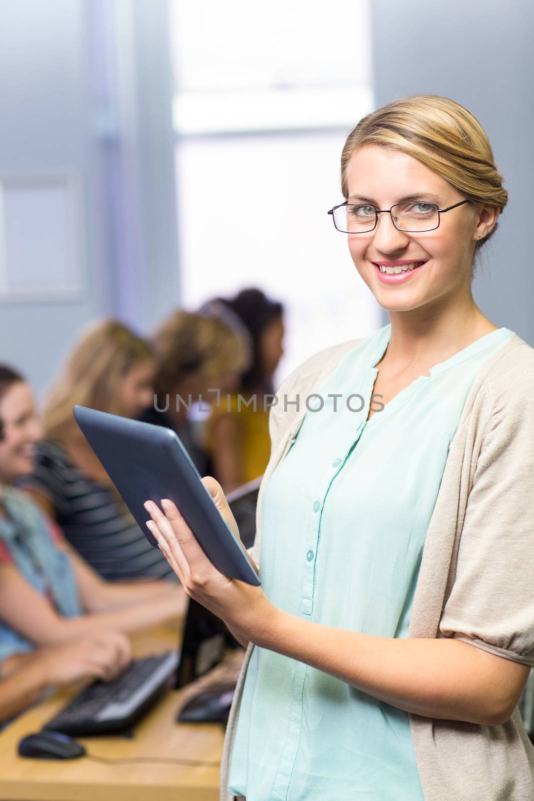 Female teacher using digital tablet in computer class