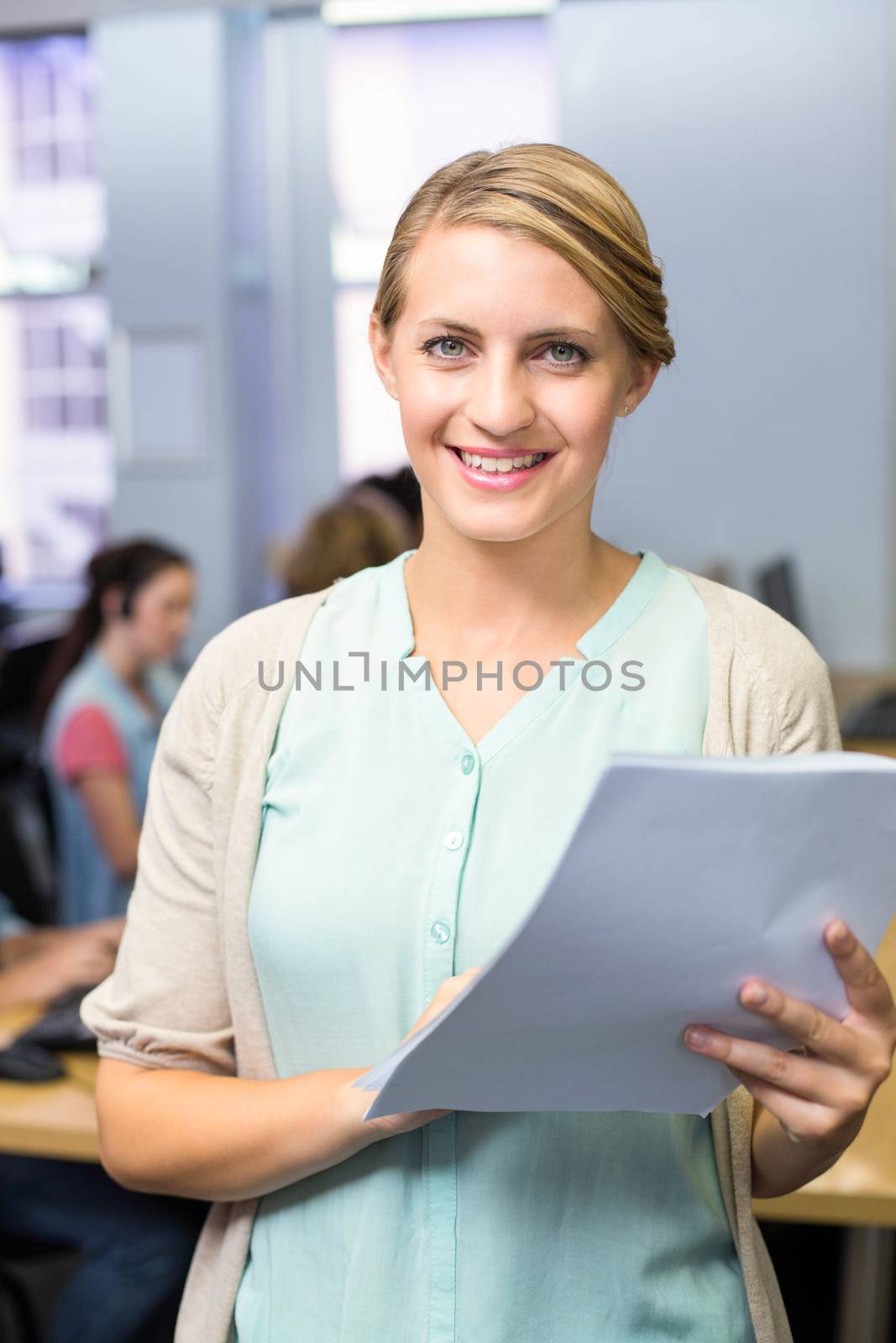 Portrait of female teacher holding document by Wavebreakmedia