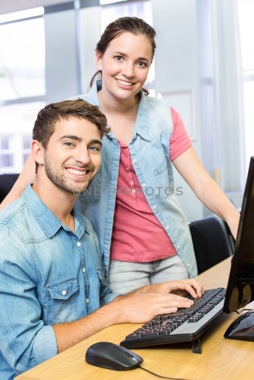Computer teacher helping pretty female student in his class