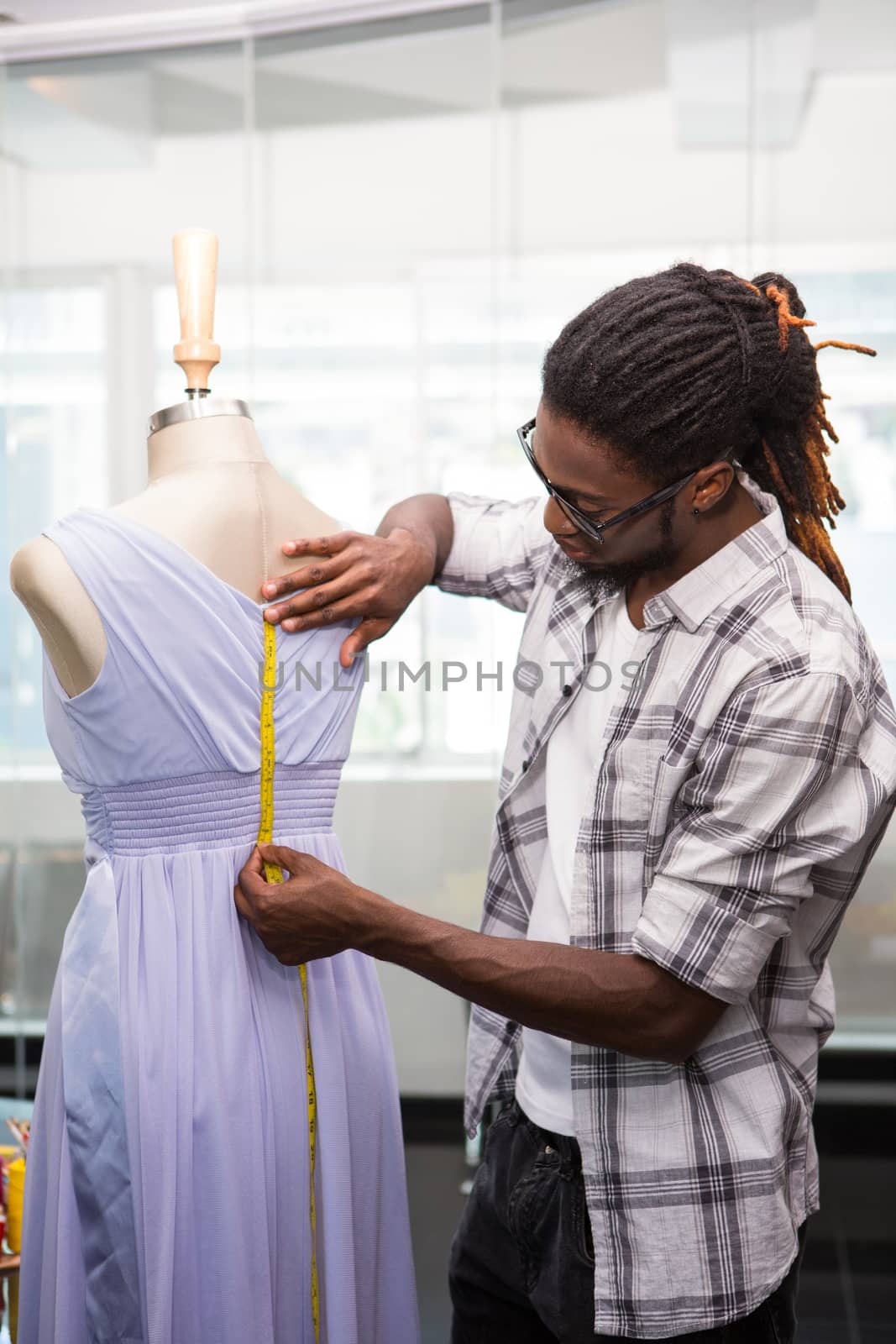 Side view of male fashion designer and mannequin