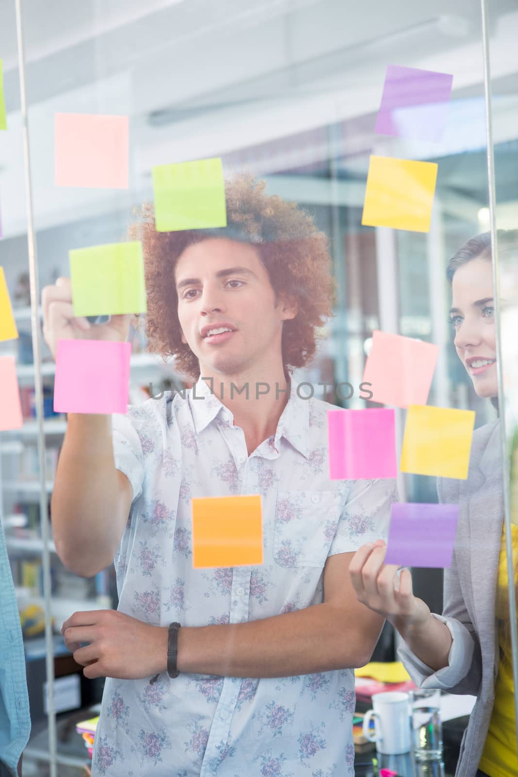 Creative business team writing on adhesive notes in office