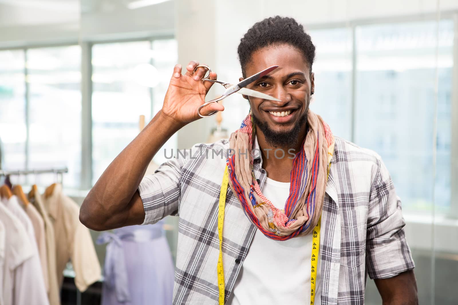 Portrait of happy male fashion designer holding scissors