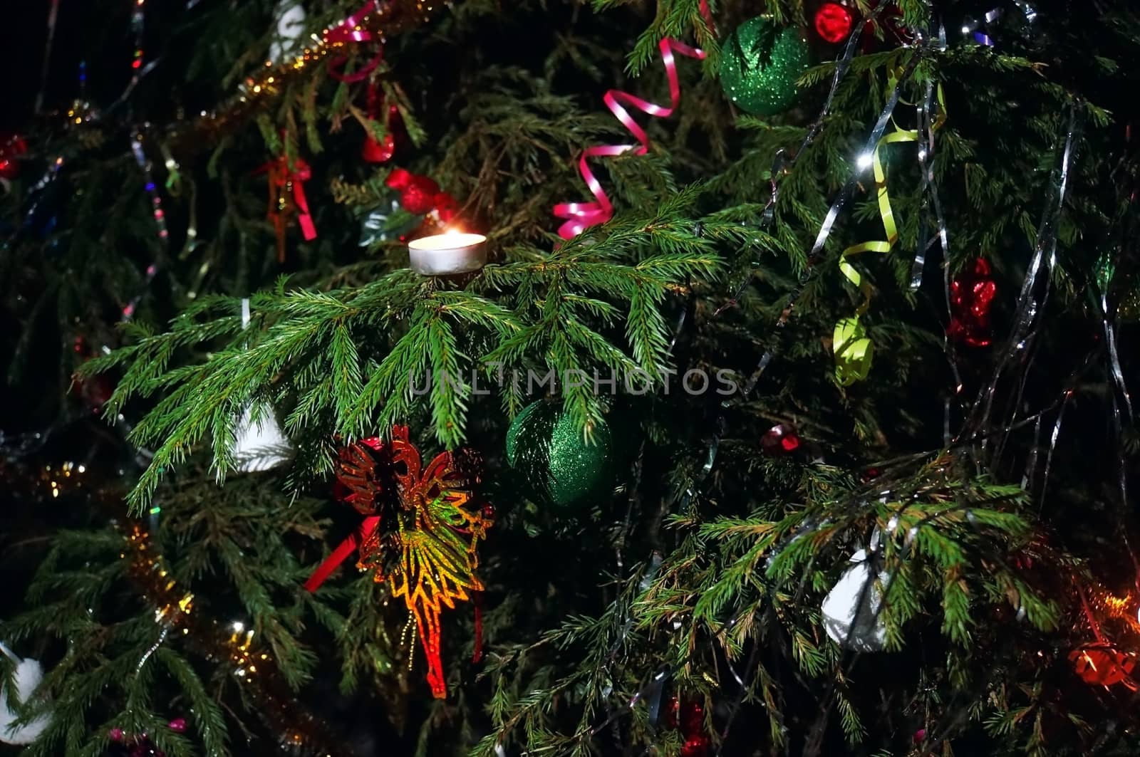 Christmas tree decorated with candles, streamers, toys close-up on the street at night                               