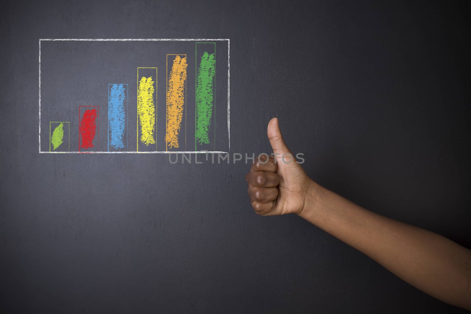 South African or African American woman teacher or student thumbs up against blackboard chalk bar graph by alistaircotton