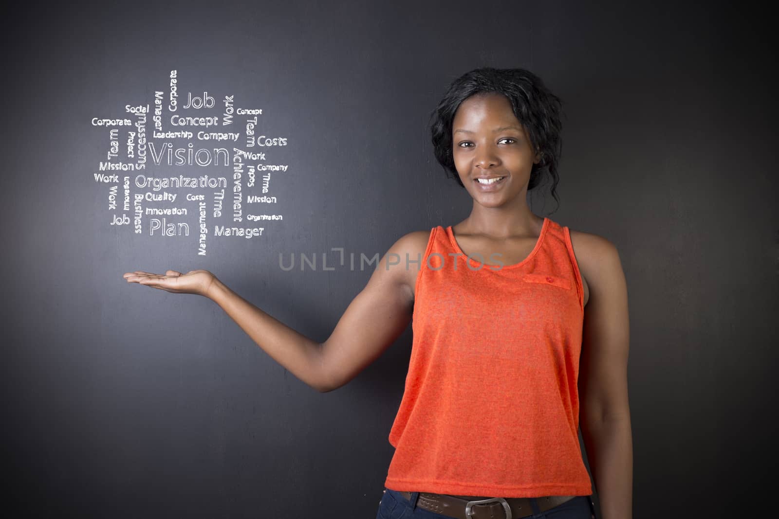 South African or African American woman teacher or student holding her hand out with a chalk vision diagram against a chalk blackboard background