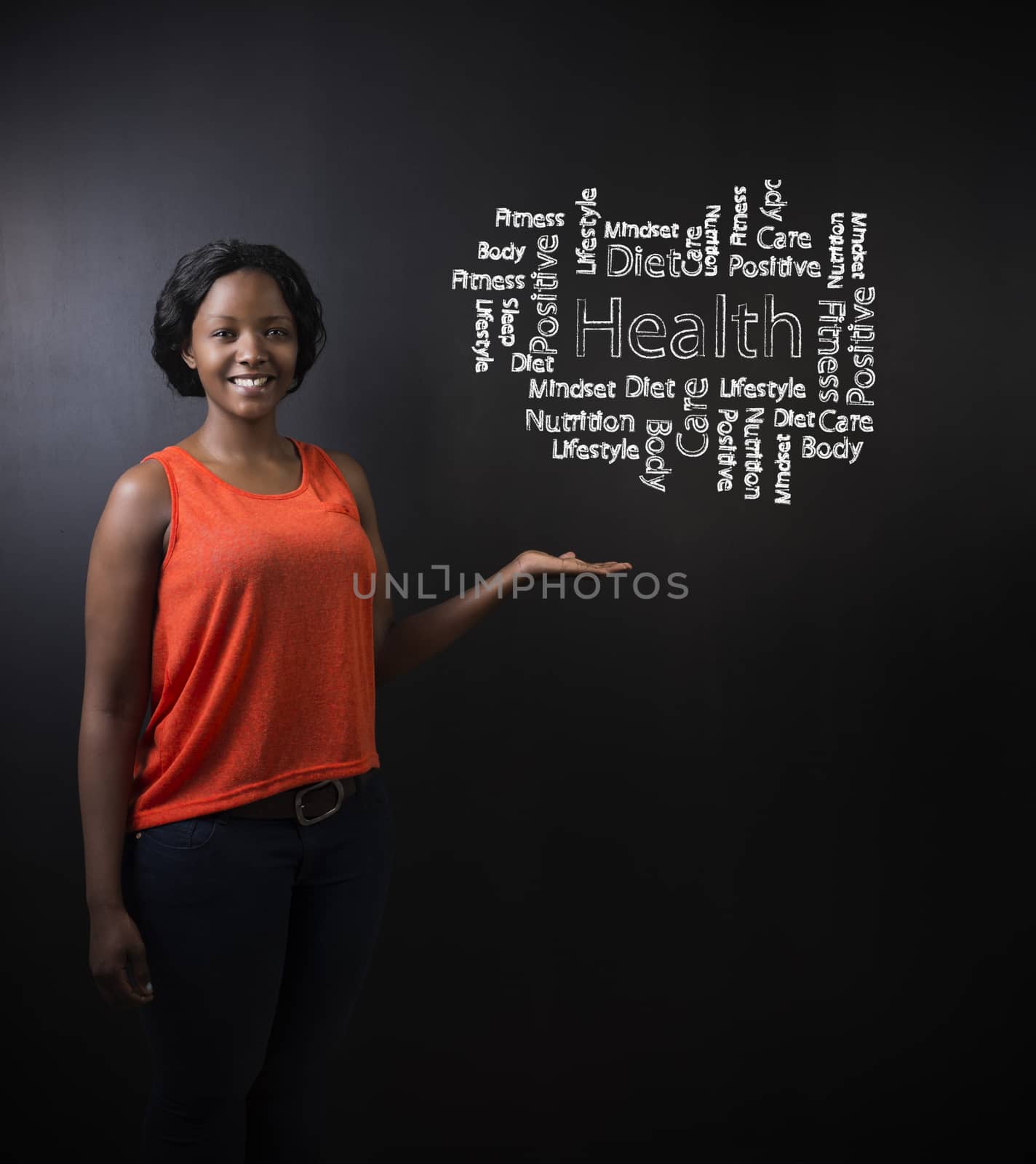 South African or African American woman teacher or student standing with her hand out against a chalk blackboard background with a chalk health diagram