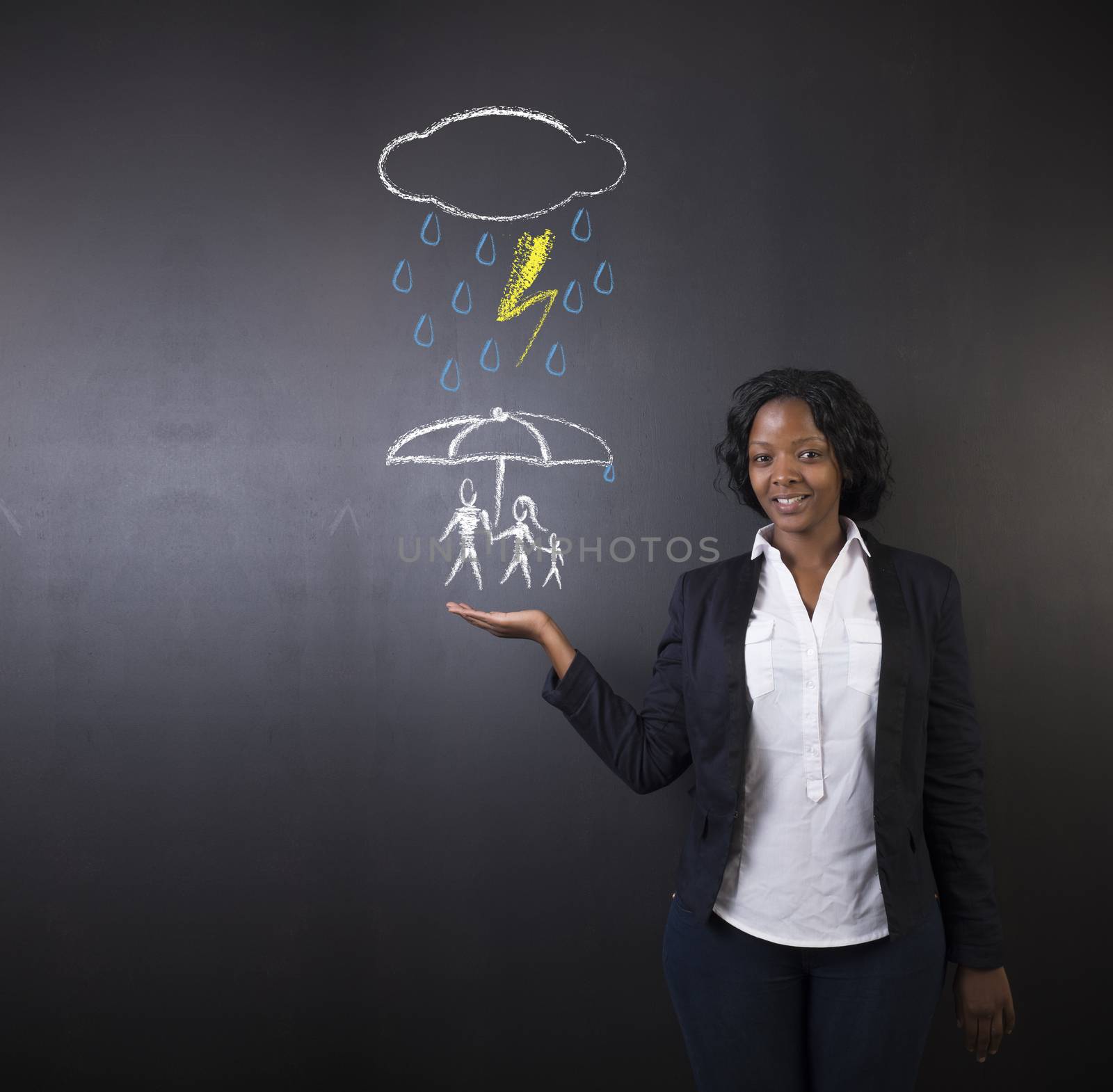 South African or African American woman teacher or student holding out her hand, displaying an insurance concept while thinking about protecting family from natural disaster on a blackboard background