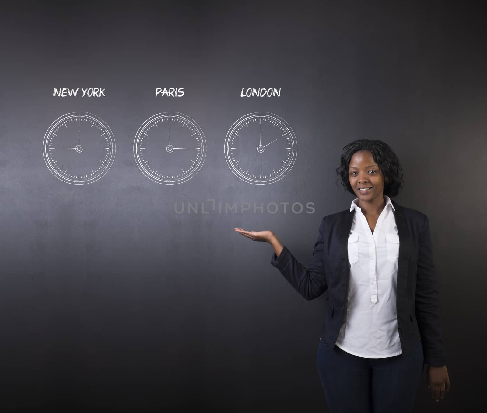 South African or African American woman teacher or student holding hand out displaying the  New York, Paris and London chalk time zone clocks on a blackboard background