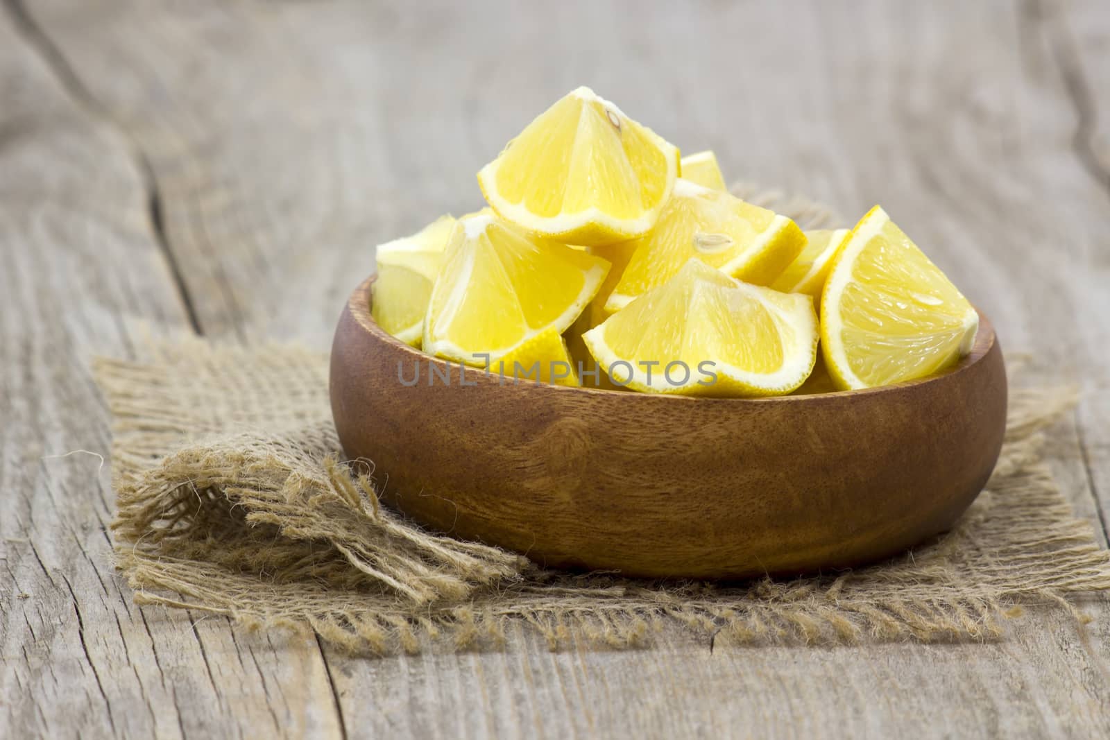 fresh lemons in a bowl on wooden background