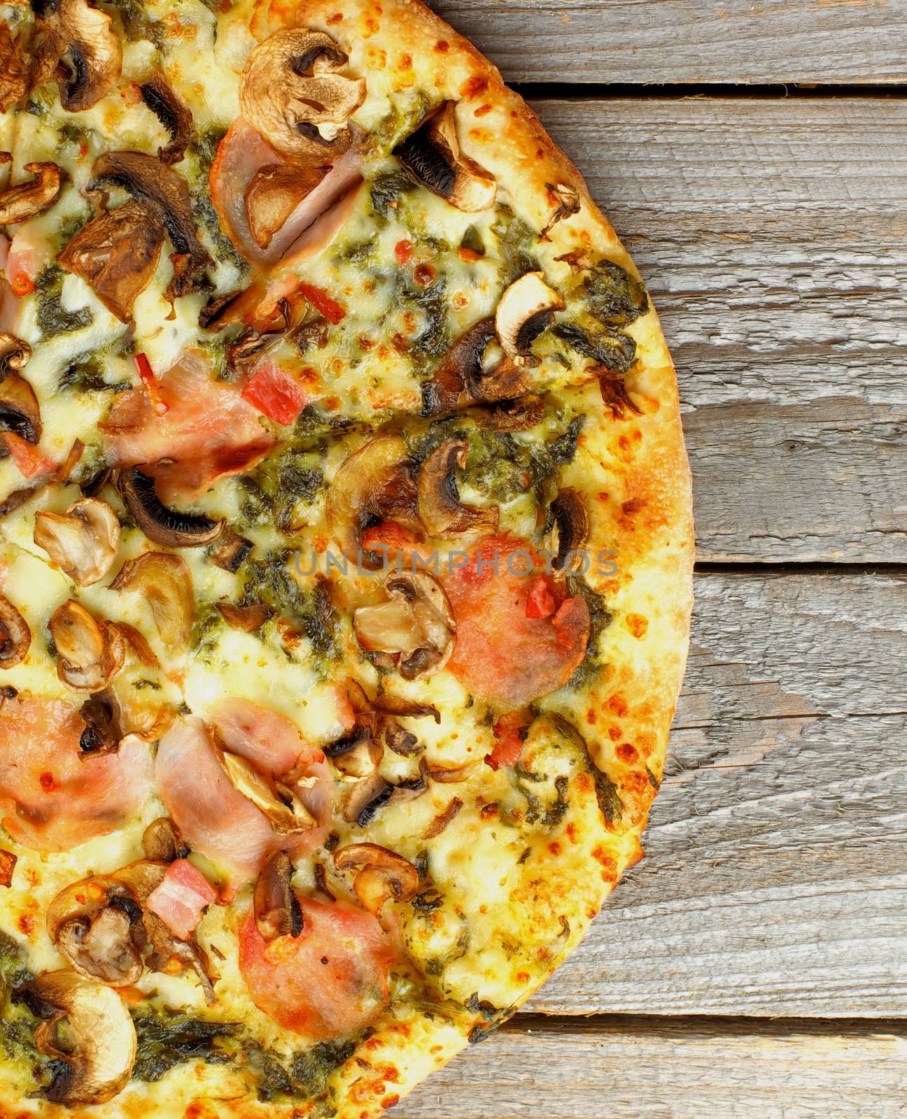 Half of Freshly Baked Pizza with Broccoli, Edible Mushrooms, Bacon, Cheese and Spinach Sauce on Rustic Wooden background. Top View