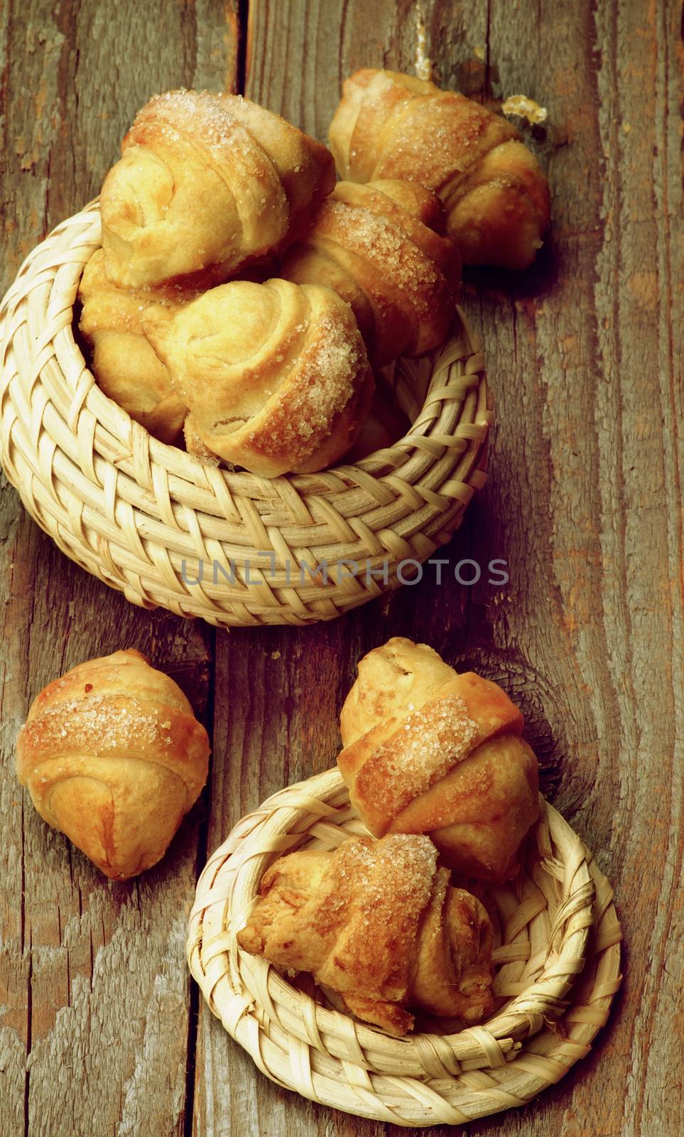 Homemade Croissant Cookies with Jam in Wicker Bowls closeup on Wooden background. Retro Styled