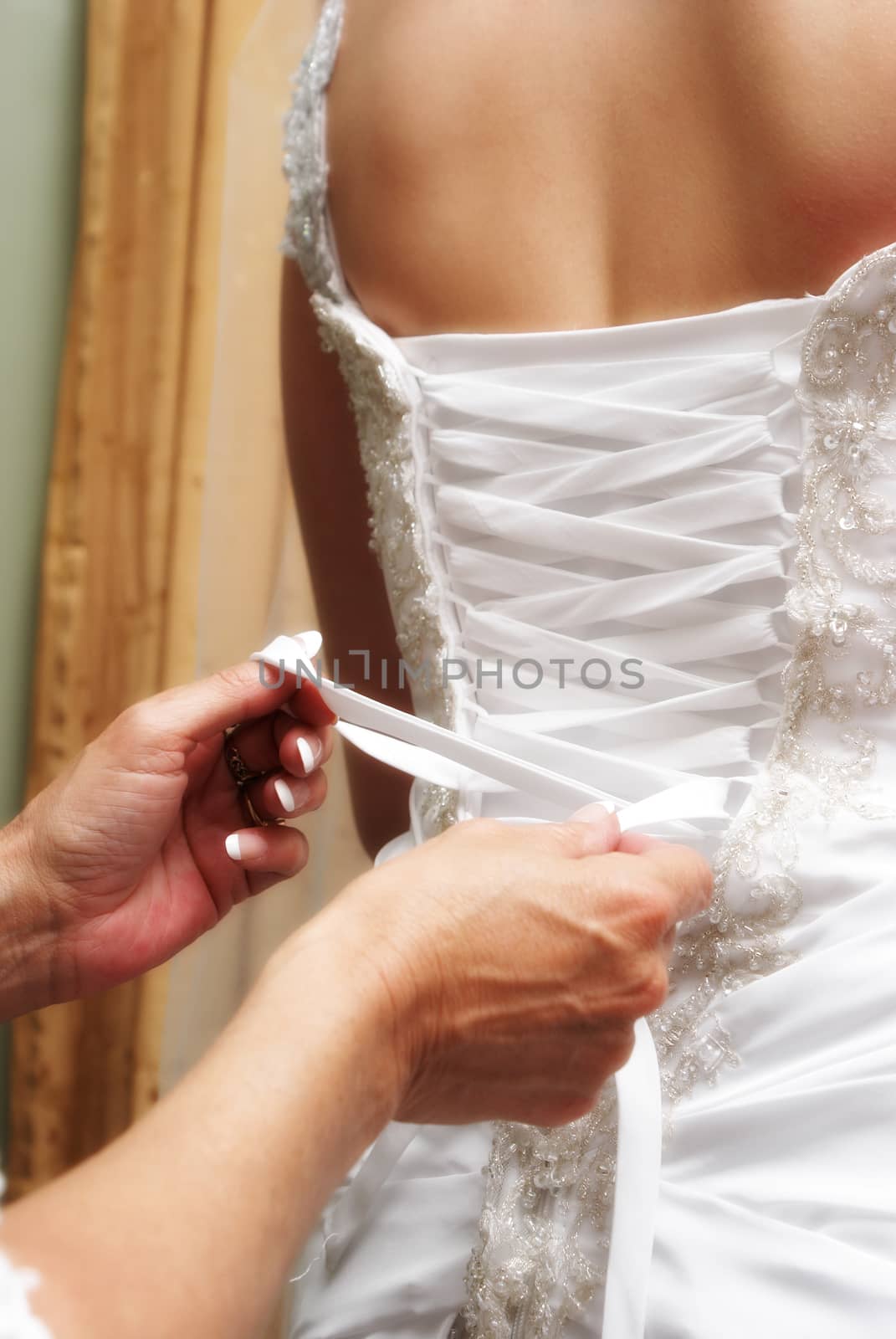 A bride to be is getting her dressed tied before her big moment of marriage.