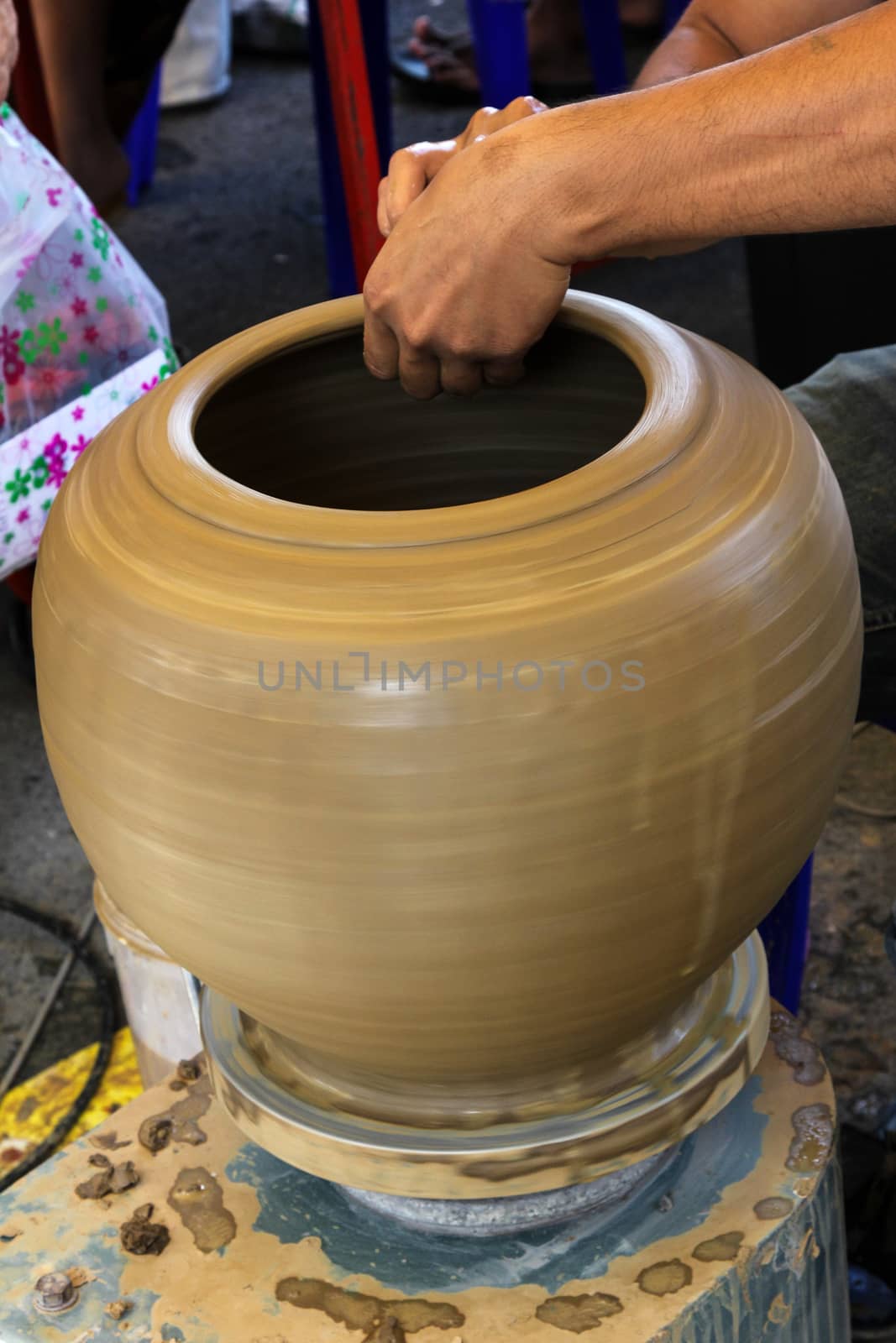 Hands of a potter making in clay on pottery wheel