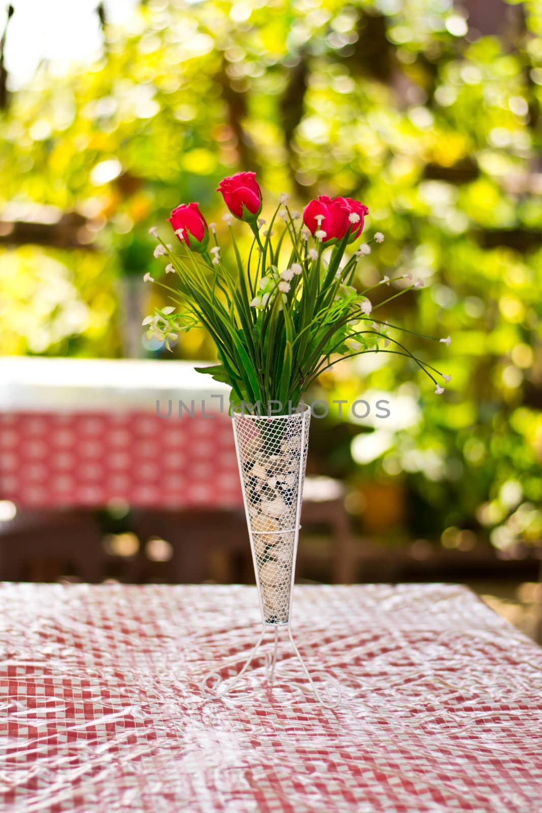  Beautiful flower in a vase on wooden table by Thanamat