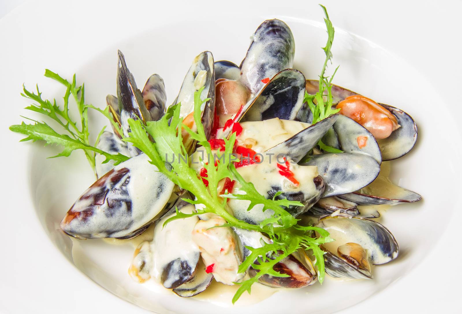 Plate of mussels in sauce with fresh herbs Isolated on white background. Restaurant shot. 