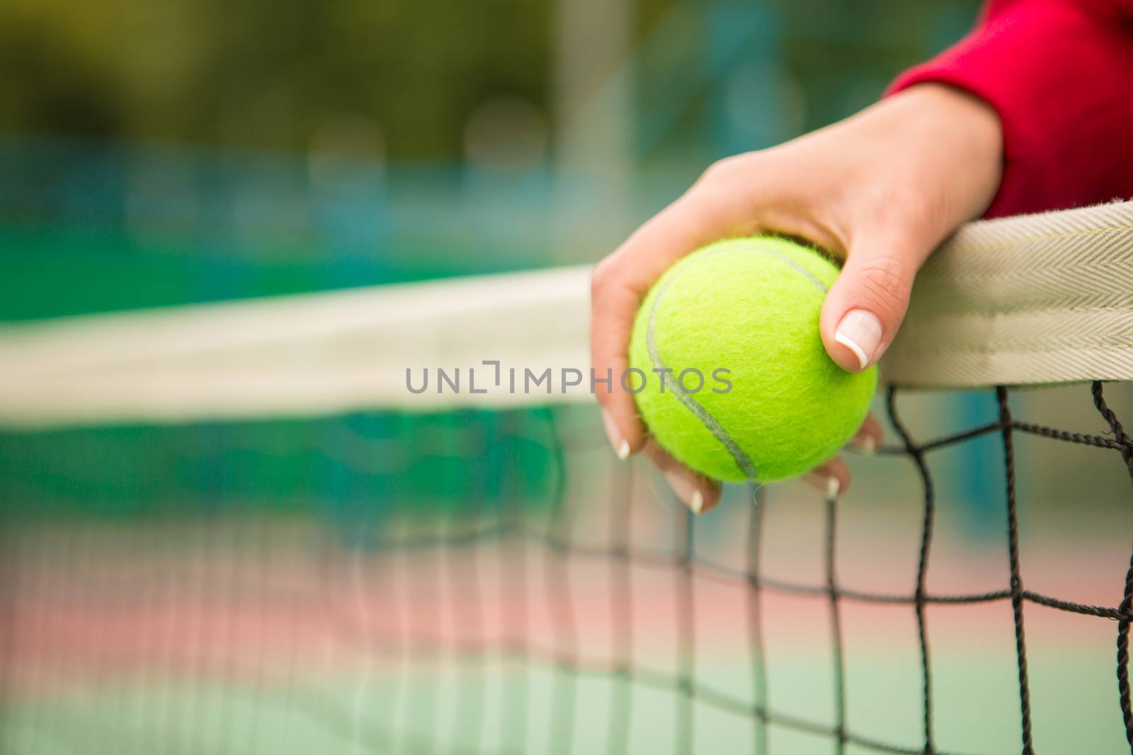 young woman with yellow ball and racket near net