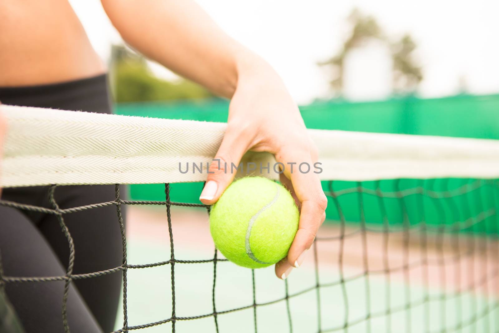 young woman with yellow ball and racket near net