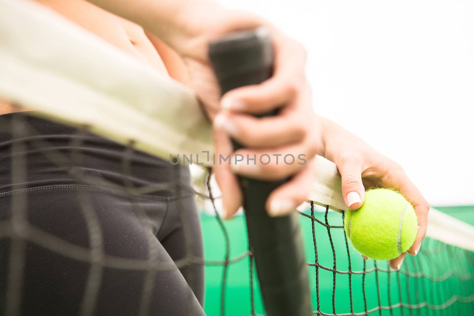 young woman with yellow ball and racket near net