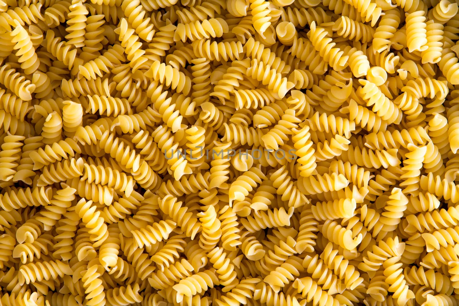 Background texture of decorative spiral shaped Italian rotini pasta with its corkscrew form in a close up full frame view