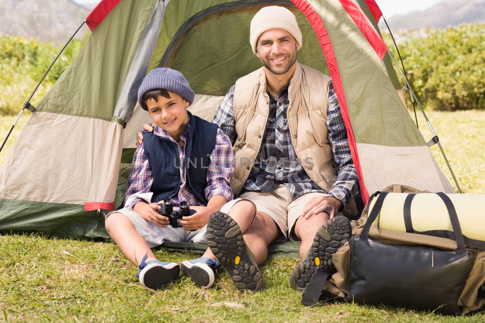 Father and son beside their tent by Wavebreakmedia