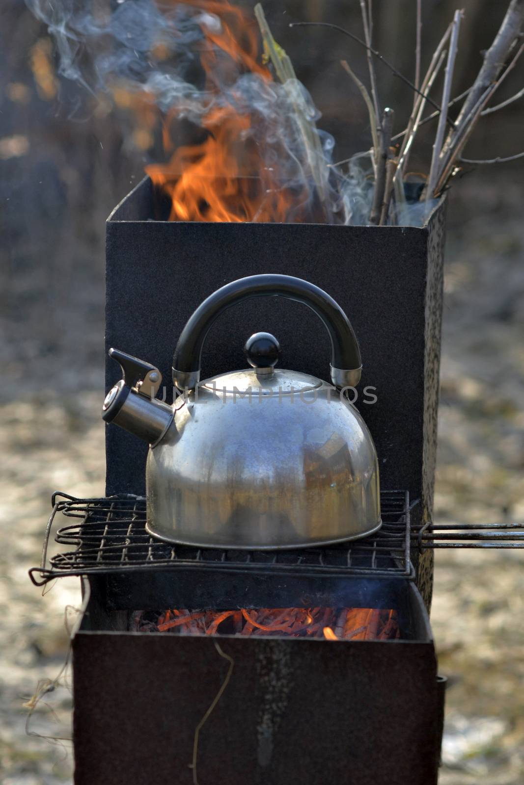 the whistling kettle begins to boil on a brazier. by veronka72