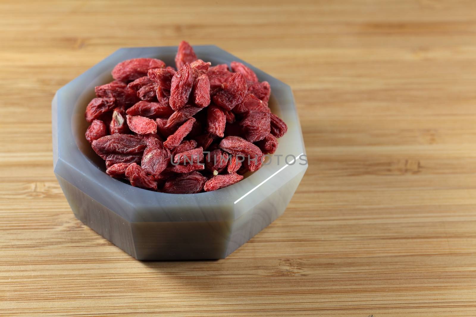 Dry goji berries in a stone mortar.