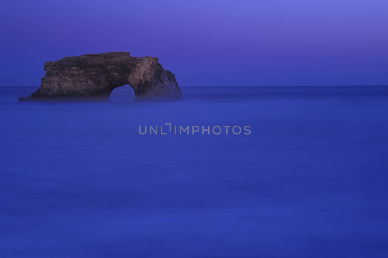 Natural Bridges rock in the Beach of Santa Cruz, California, USA. With ocean wave in the foreground.