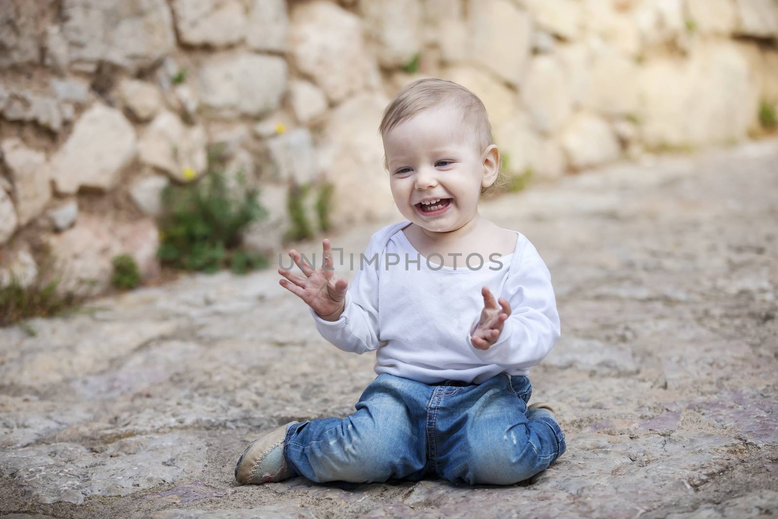 Cute little boy crawling on stone paved sidewalk by photobac