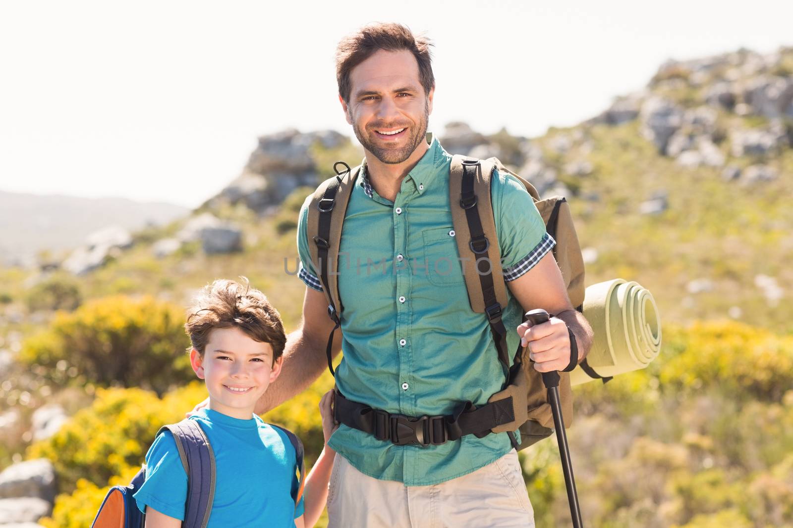 Father and son hiking through mountains on a sunny day