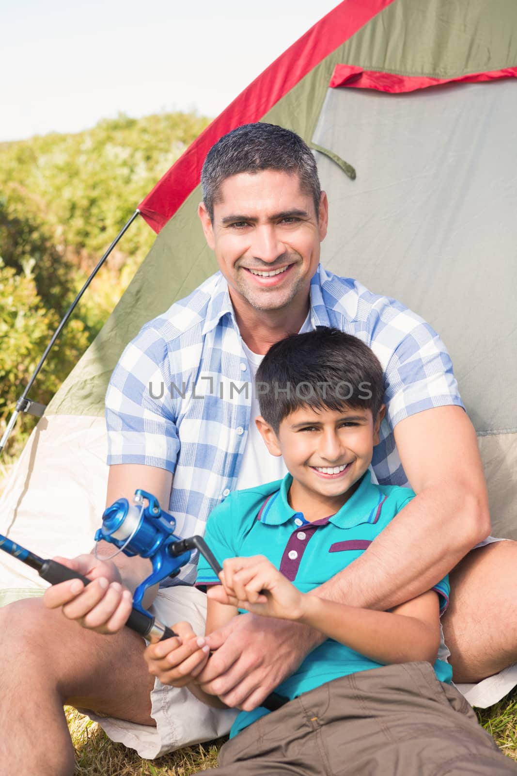Father and son beside their tent on a sunny day