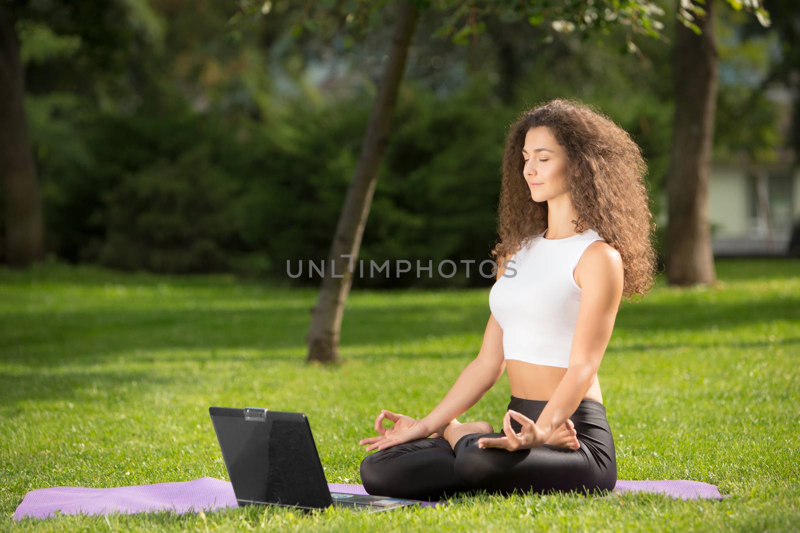 Meditating woman with laptop by master1305
