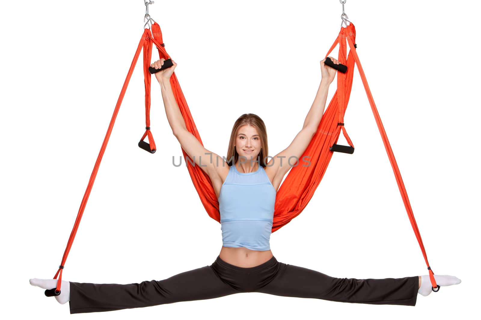 Young woman making antigravity yoga exercises in stretching twine with red hammock on a white background