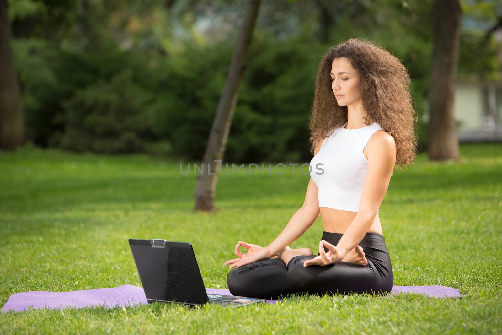 Meditating woman with laptop by master1305