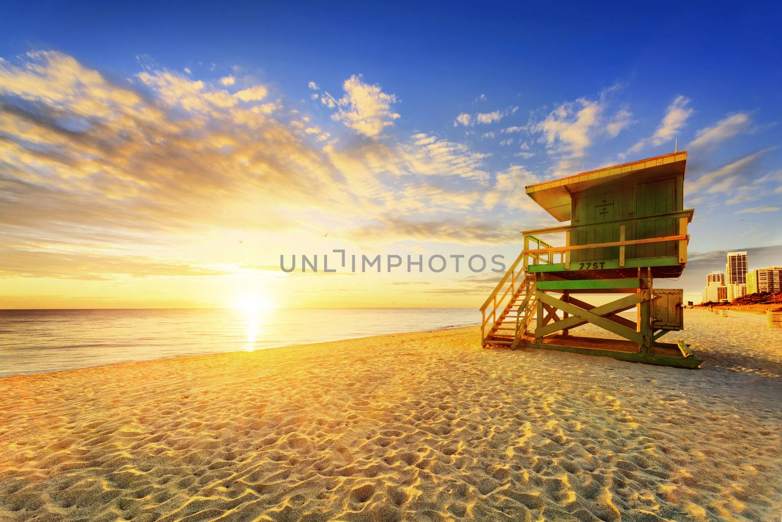 Miami South Beach sunrise with lifeguard tower and coastline with colorful cloud and blue sky. 