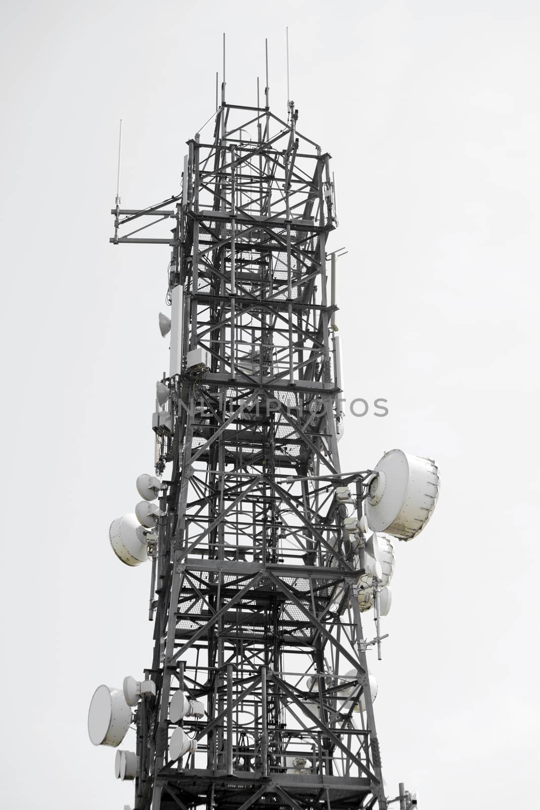 communications tower against a white sky by morrbyte