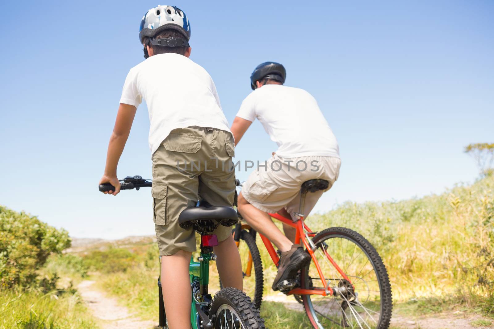 Father and son biking through mountains on a sunny day
