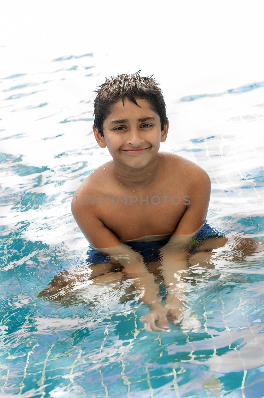 An handsome Indian kid having fun at pool