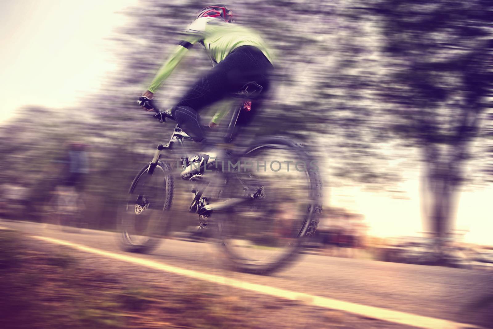 Low angle view of cyclist riding mountain bike with speed effect