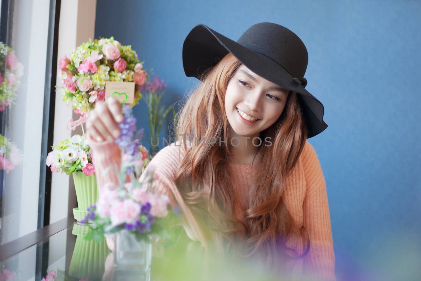 Long haired asia girl happy smile mirror reflection with beautiful flower.