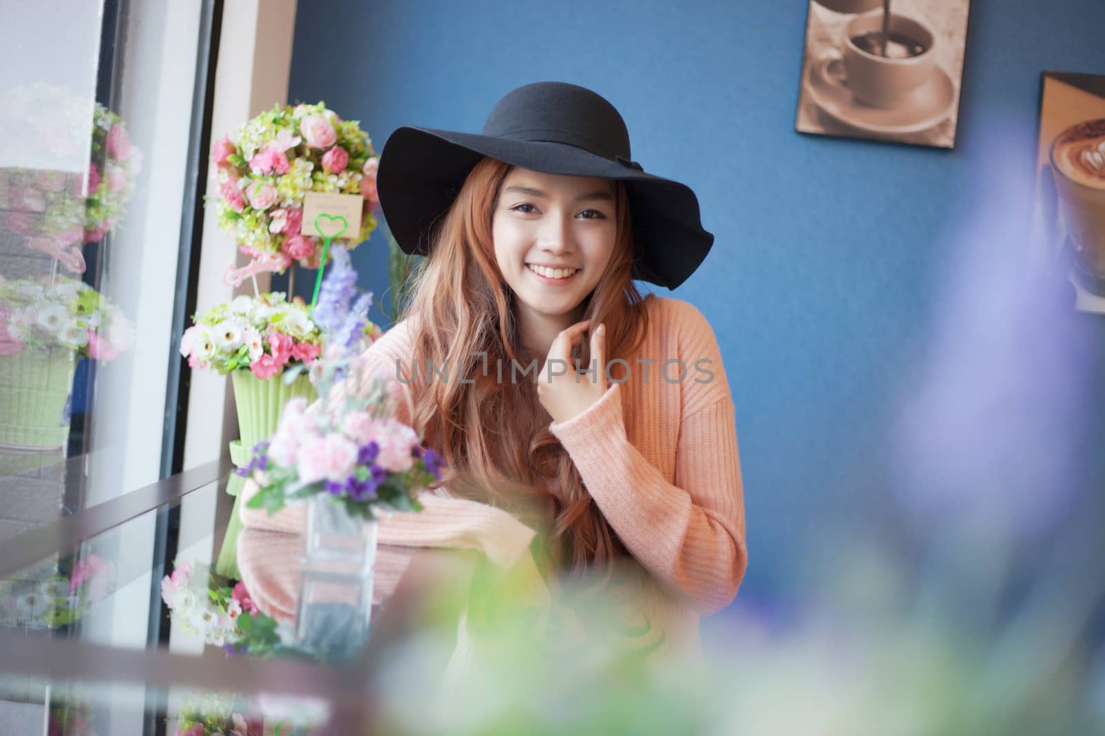 Long haired asia girl happy smile mirror reflection with beautiful flower.