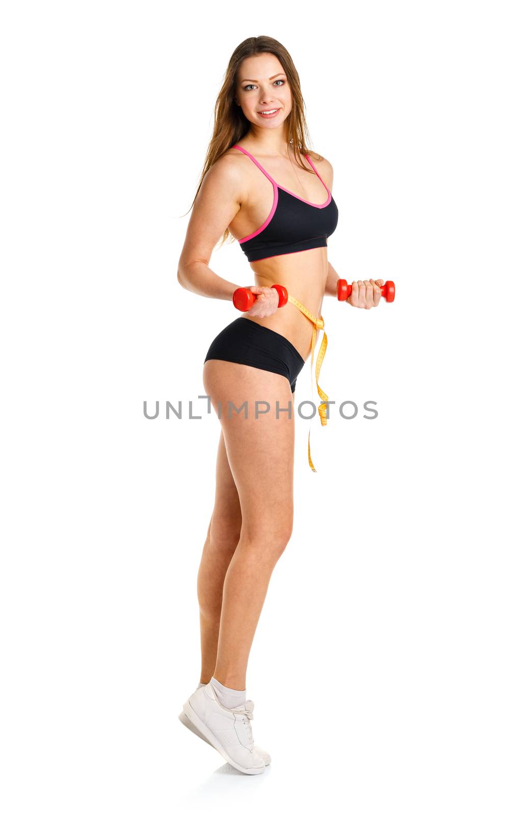 Beautiful athletic woman with dumbbells and measuring tape on waist doing sport exercise, isolated on white background