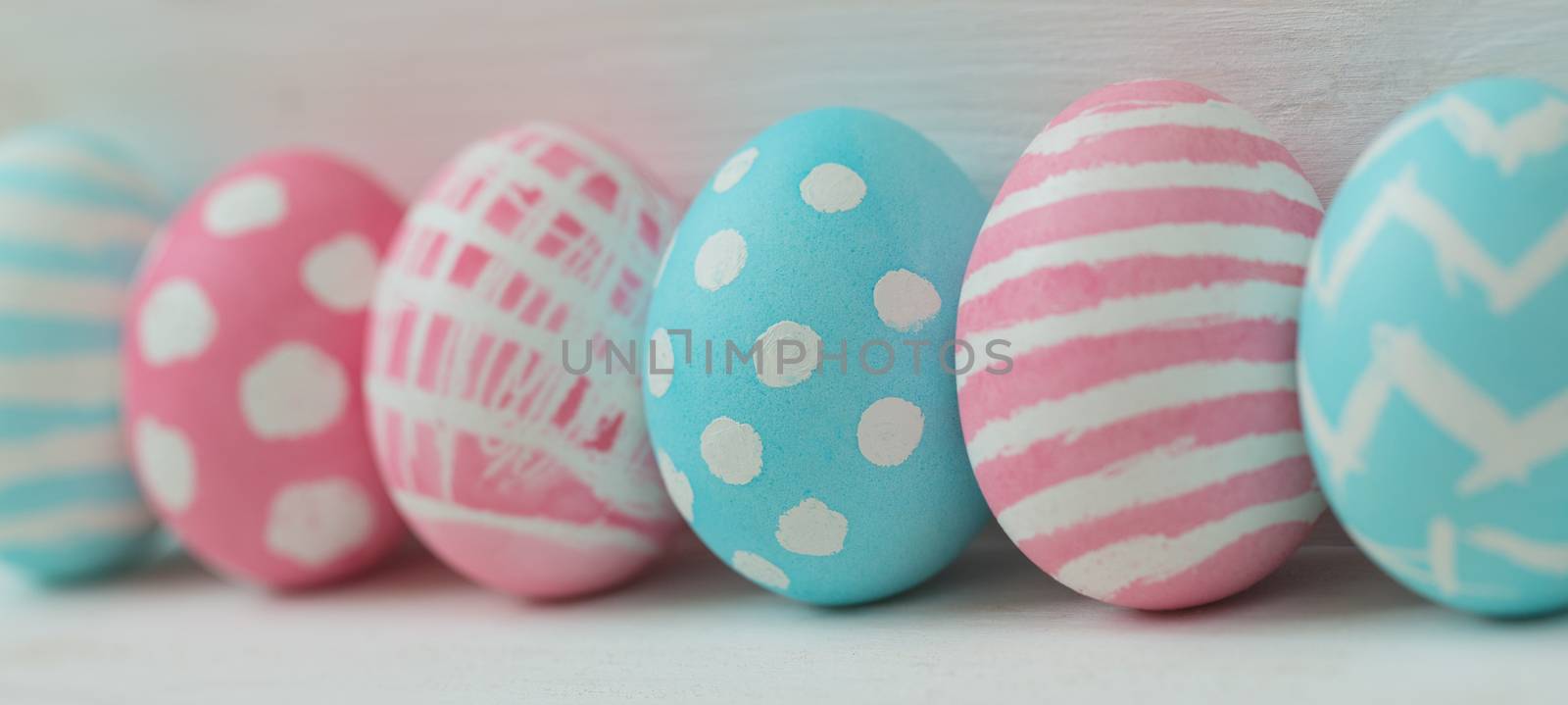 Pink and blue easter eggs on a wooden background