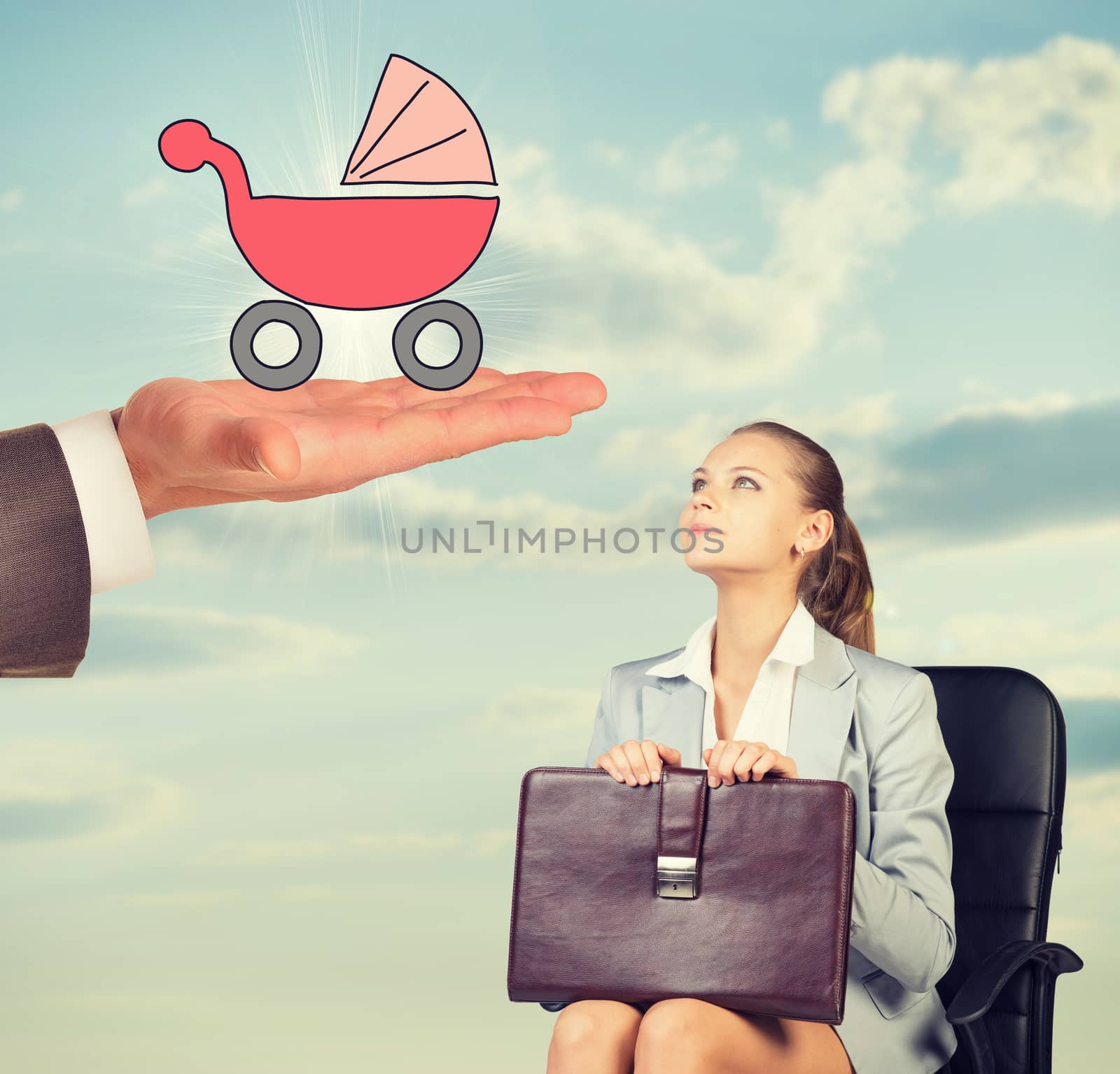 Young woman sitting in chair and looking up at mans hand holding baby carriage