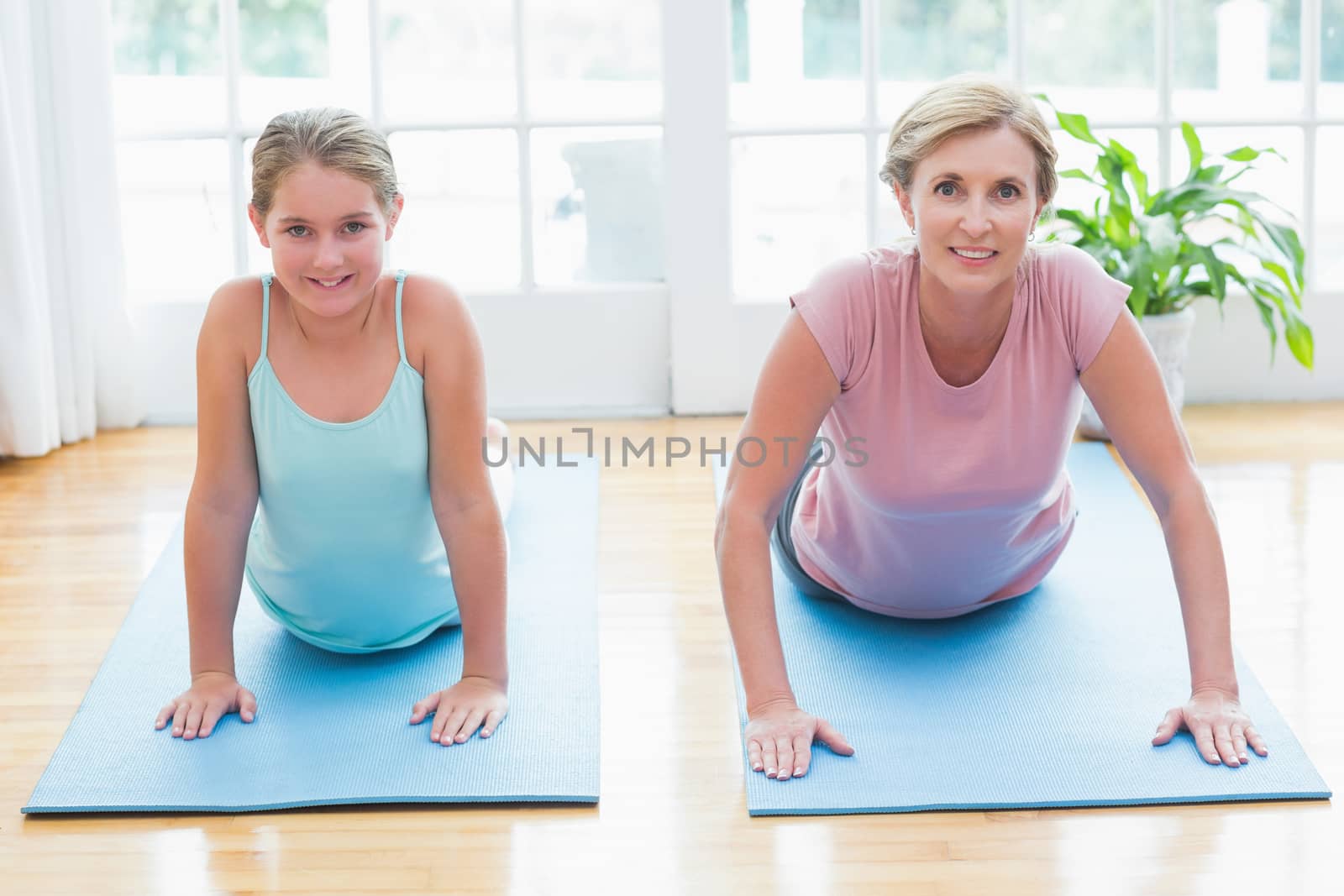 Happy mother and daughter doing yoga  by Wavebreakmedia