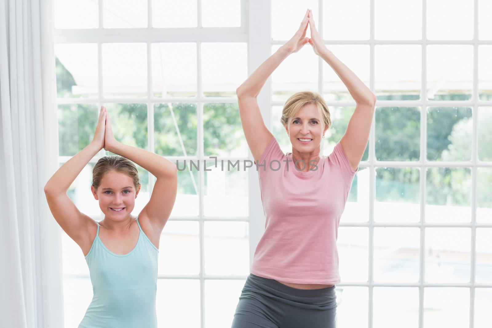 Mother and daughter doing yoga  by Wavebreakmedia
