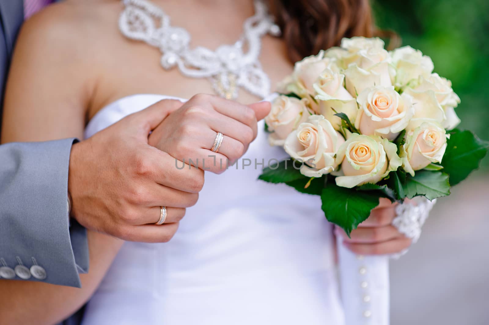 Hands and rings and wedding bouquet.